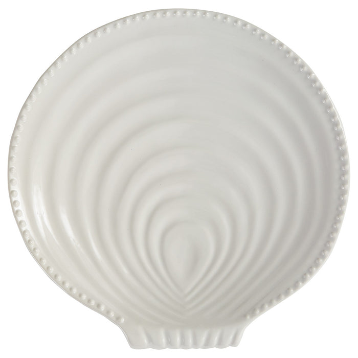 Top view of white ceramic seashell dinner plate with raised shell pattern and beaded edge detail.